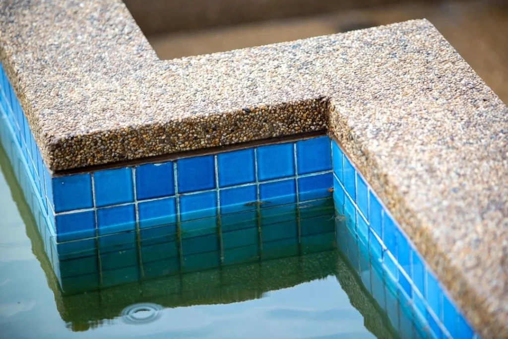 old and dirty pool with outdated tiles